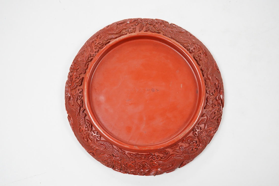 A Chinese cinnabar lacquer 'dragon' dish, signed to the base, 19cm in diameter